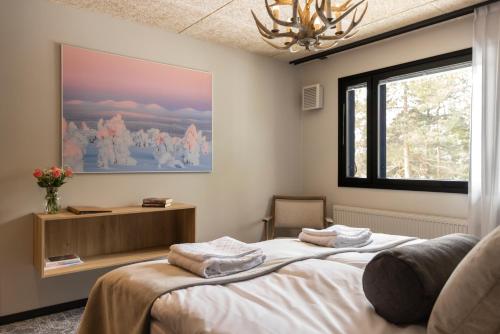 a bedroom with a bed with towels on it at Kelo Resort in Raattama