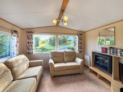 a living room with a couch and a chair and a tv at Hafren View in Machynlleth
