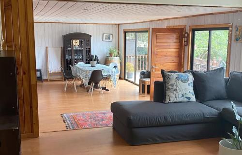 a living room with a couch and a table at Casa en la playa con piscina in Guanaquero