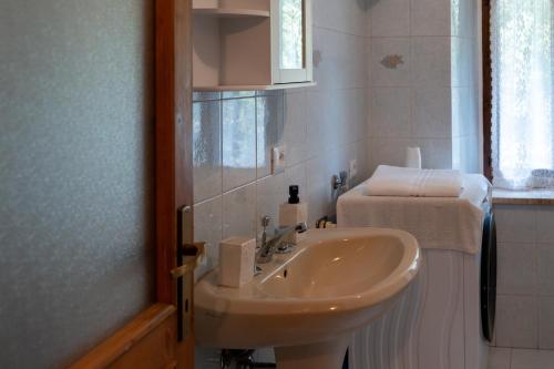 a white bathroom with a sink and a mirror at Wooden Stories - Nature, Netflix & Wi-Fi in Socchieve