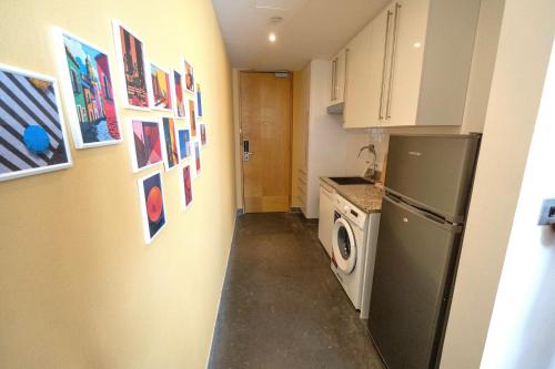 a kitchen with a refrigerator and a washing machine at Luxury Homestay Near Dubai World Trade Centre in Dubai
