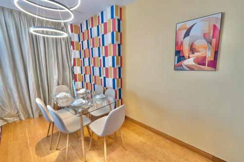 a dining room with a glass table and white chairs at Luxury Homestay Near Dubai World Trade Centre in Dubai