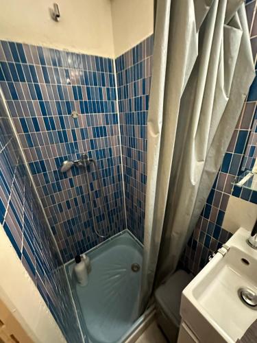 a blue tiled bathroom with a shower and a sink at Simplicité au Centre de Montpellier in Montpellier