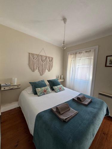 een slaapkamer met een groot bed met handdoeken erop bij Casa Clara in Aveiro