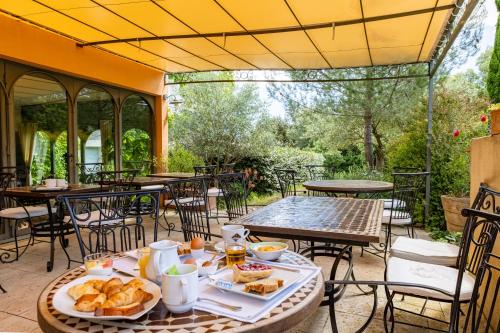 Hotel Restaurant Le Gardon - Pont du Gard في Collias: طاولة عليها طعام في الفناء