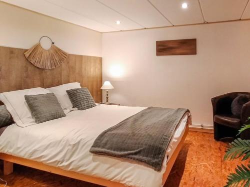 a bedroom with a large bed and a chair at La Belle vue in Durbuy