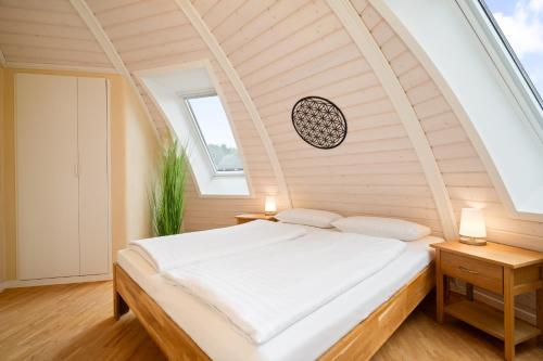 a bed in a room with an arched ceiling at Kugelhaus Nordlichter - Skandinavischer Rückzugsort in runder Form am Tollensesee in Wustrow