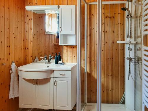 a bathroom with a sink and a shower at Charming Cottage Near The Sea On Rossö in Nyckleby