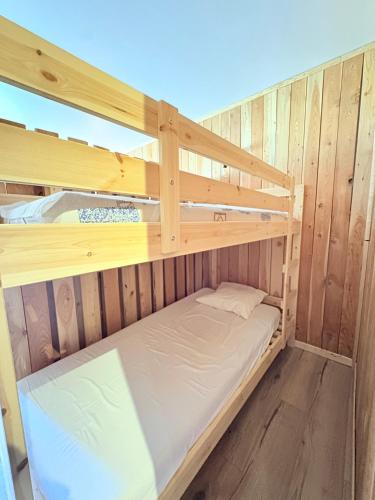 a couple of bunk beds in a wooden room at Le Balcon du Bois in Le Dévoluy