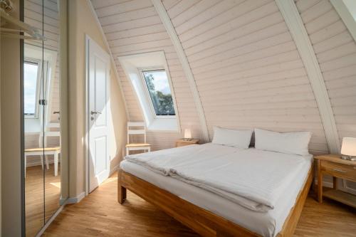 a bedroom with a large bed in an attic at Kugelhaus Chiara - Helles Naturrefugium in Kugelform am Tollensesee in Wustrow