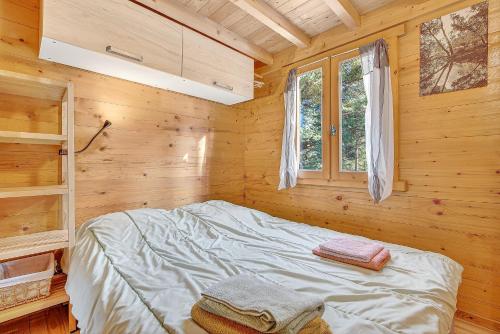 a bedroom with a bed in a wooden cabin at Chalet Le Mazet in Les Prats