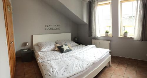 een slaapkamer met een bed met witte lakens en kussens bij Ferienwohnung Möwe in Glowe