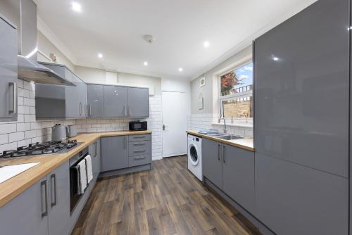 a large kitchen with white appliances and a window at modern 4 bdr house rock ave in Gillingham