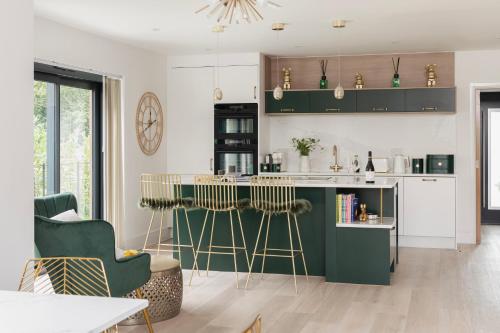 una cocina con una isla verde con taburetes de bar en Gable View, en Holcombe