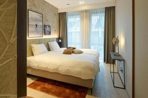 a bedroom with a bed and a large window at Droomsuites Texel 4 personen by Droomvilla in Den Burg