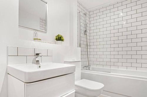 a white bathroom with a sink and a toilet at Charming Deritend Apartment with Full Access for Wheelchairs in Birmingham