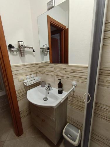 a bathroom with a sink and a toilet and a mirror at Aris in Alghero