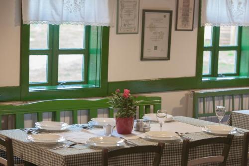 a table with plates and a vase of flowers on it at Pension Kezele in Graberje Ivanićko