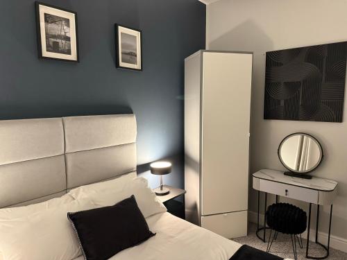 une chambre avec un lit, un miroir et un bureau dans l'établissement Modern 1 & 2 Bedroom Apartments near Queens University Belfast by MonoStays, à Belfast