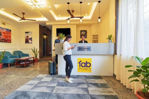 Una mujer parada en una cabina de peaje en una oficina. en FabHotel Samrat Regency, en Udaipur