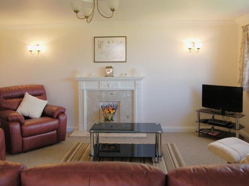 パドストウにあるSea Whispersのソファと暖炉のあるリビングルーム