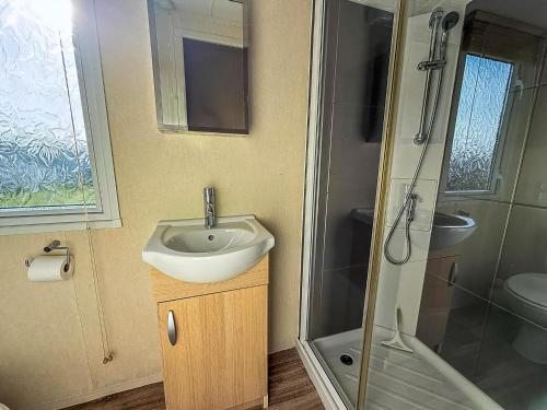 a bathroom with a sink and a shower at Lovely Caravan With Spacious Decking At North Denes In Suffolk, Ref 40134Nd in Lowestoft