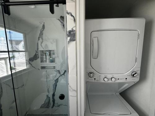 a shower with a glass door next to a shower at Wifi Decks Private Yard Beach Badges Beach Chairs Keurig Os Wd 3Rd Off The Beach in Brant Beach