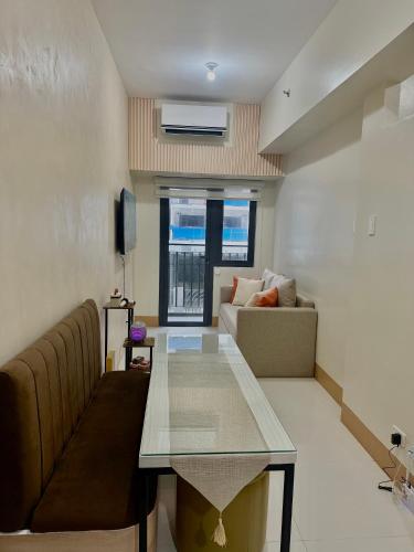 マニラにあるSoléa Suitesのテーブルとソファのあるリビングルーム