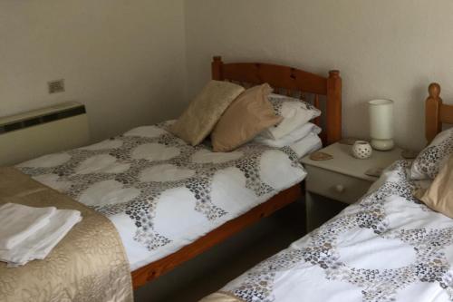 a bedroom with two twin beds and a night stand at Cottage - Sleeps 4 - Pets Ok - Garden - Parking in Keswick