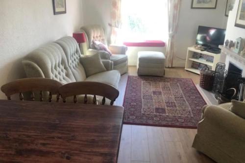 a living room with a couch and a table at Talcomb Cottage in Thornthwaite Keswick in Keswick