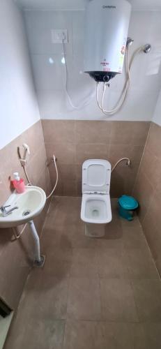 a bathroom with a toilet and a sink at A J Home Stay in Tiruvannāmalai