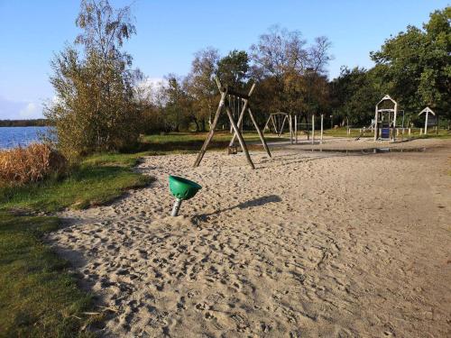 a playground with a green object in the sand at 4 person holiday home in Ansager in Ansager