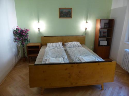 a large wooden bed in a room with two mattresses at Retro Apartment in Brezno