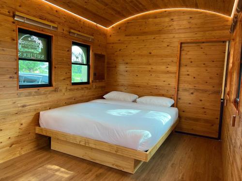 a bedroom with a bed in a wooden cabin at SafeHouse resort เซฟเฮ้าท์รีสอร์ท 