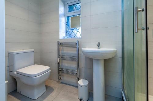 a bathroom with a toilet and a sink and a window at Windsor Reach in Datchet