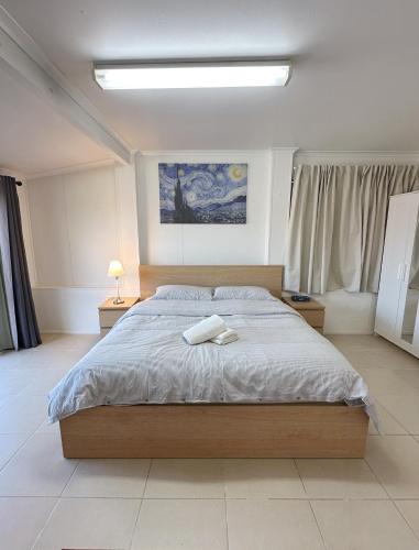 a bedroom with a large bed and two night stands at Ella sweet home in Algester