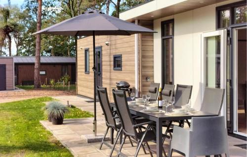 a table and chairs under an umbrella on a patio at Amazing Home In Hellendoorn With Sauna in Hellendoorn