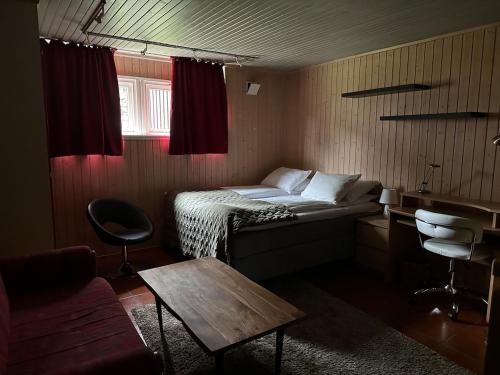 a small room with a bed and a table in it at Bytoppen top of the island in Tromsø