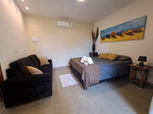 a living room with a bed and a couch at Recanto Tucuns-Guest House in Búzios