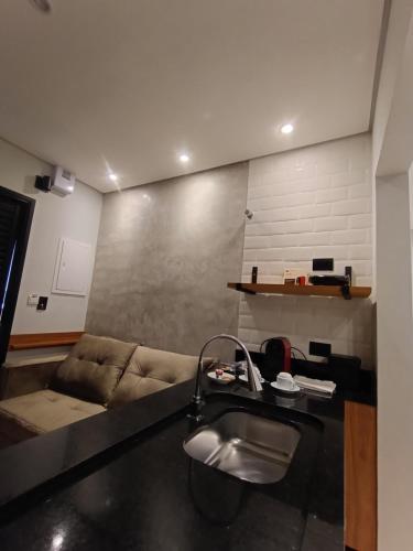 サン・ミゲウ・アルカンジョにあるApart Hotel da Serraのリビングルーム(シンク、ソファ付)