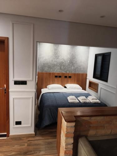 サン・ミゲウ・アルカンジョにあるApart Hotel da Serraの大きなベッドと暖炉のある寝室