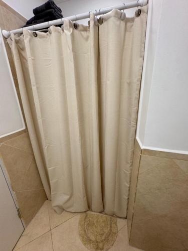 a shower curtain in the corner of a bathroom at Don Antonio Apart 2 in Resistencia