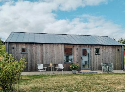 a wooden building with two chairs and a table at Modern Guest House Near The Sea In Brösarp in Brösarp