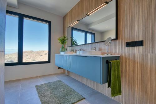 a bathroom with a blue sink and a mirror at La Atalaya del Salobre Golf in San Bartolomé