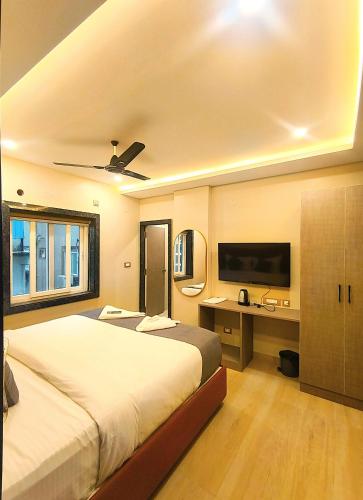 a bedroom with a bed and a desk and a tv at Mio Boutique Hotel - Just Launched in Hyderabad