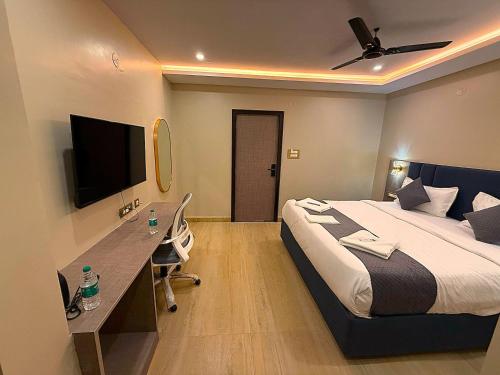 Un dormitorio con una cama, un escritorio y un televisor. en Mio Boutique Hotel - Just Launched, en Hyderabad