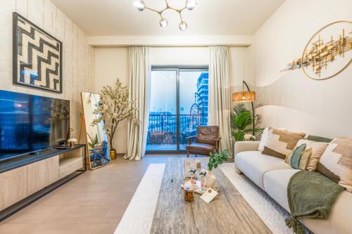 a living room with a couch and a tv at Designer 1 Bedroom Apartments in Dubai Hills Estate in Dubai