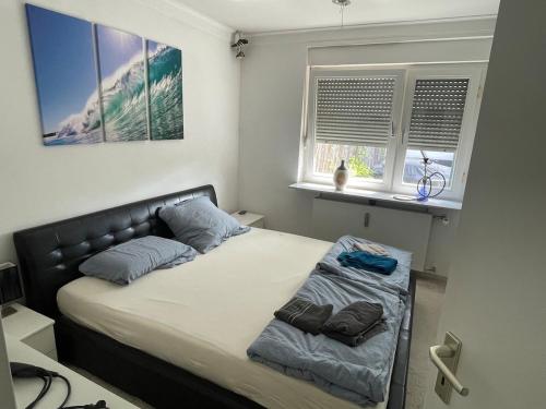 a bedroom with a bed with two pillows and a window at Casa Pelzerro in Aachen