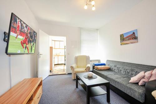a living room with a couch and a tv at Stadtquartier Kiek In in Parchim