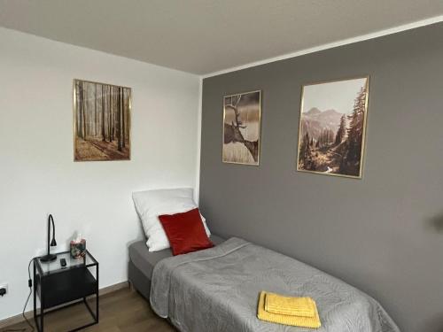 1 dormitorio con 1 cama y 3 cuadros en la pared en LGH2-4 Schlafzimmer, voll ausgestattet, WLAN, Balkon, self-check-in, en Langenhagen